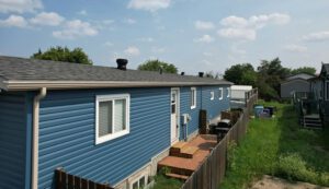 A blue house featuring blue siding and a matching blue roof, set against a clear sky